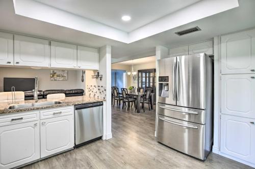 a kitchen with white cabinets and a stainless steel refrigerator at Movie Room and Private Pool Richardson Retreat in Richardson