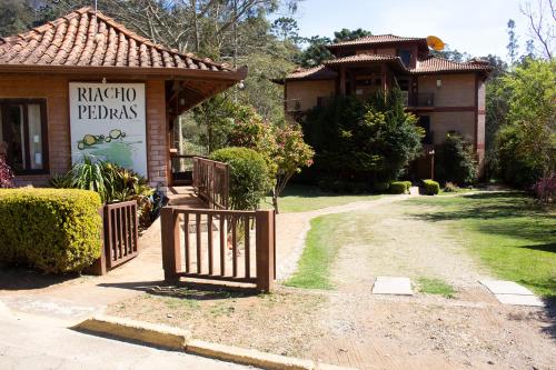 Riacho Das Pedras Pousada في جونسالفيس: لافته امام بيت مع بوابه
