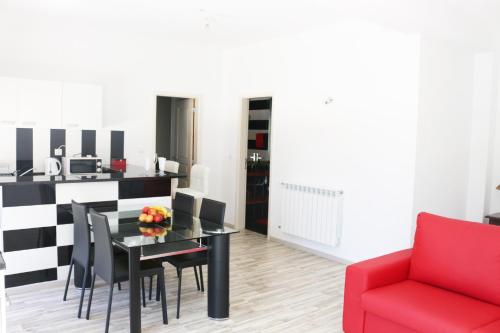 een woonkamer met een tafel en een rode stoel bij Alojamento Local S. Bartolomeu in Trancoso