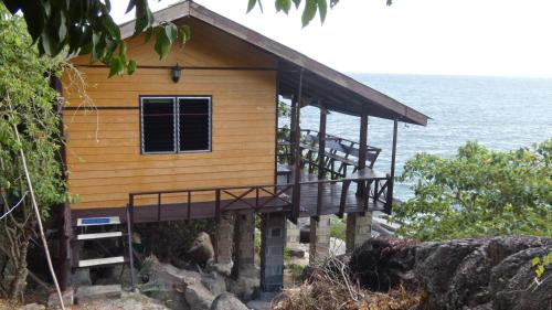a house on the beach with the ocean behind it at Tao Thong Villa 2 in Ko Tao