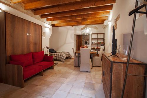een woonkamer met een rode bank en een tafel bij la casetta in Sassari