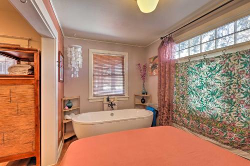 a bathroom with a bath tub and a window at The Purple House Apt in Downtown Flagstaff! in Flagstaff