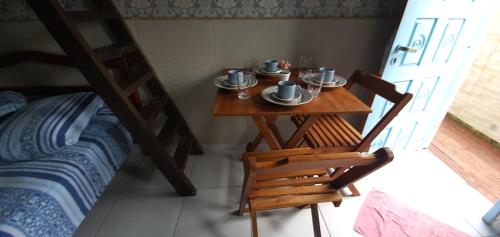バーハ・デ・イビラケラにあるKitnet Barra de Ibiraqueraのテーブル、椅子、二段ベッドが備わる客室です。