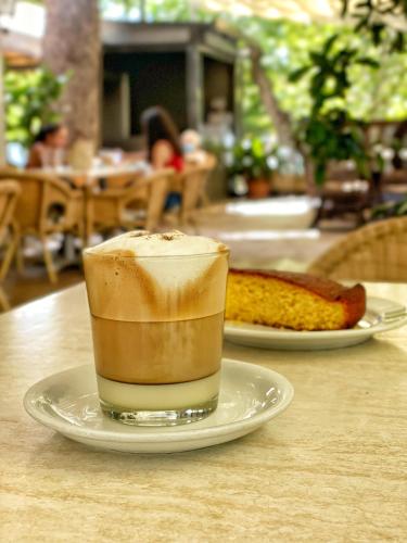 a cup of coffee on a plate on a table at Hospedium Hotel Los Lanceros in San Lorenzo de El Escorial