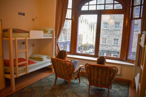 two children sitting in chairs in a room with a window at Royal Mile Backpackers in Edinburgh