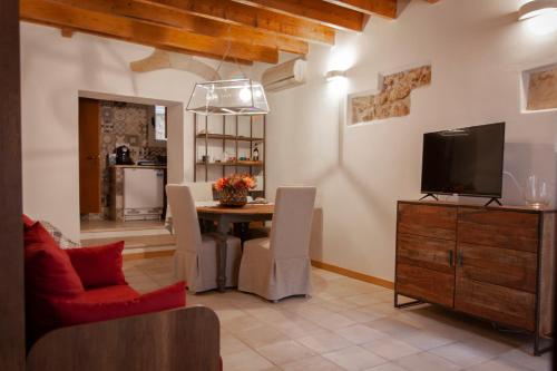 a living room with a table and a tv at la casetta in Sassari