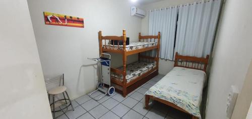 Habitación pequeña con cama y mesa en Apartamento na praia de Bombas Edifício Umuarama bloco B, en Bombinhas