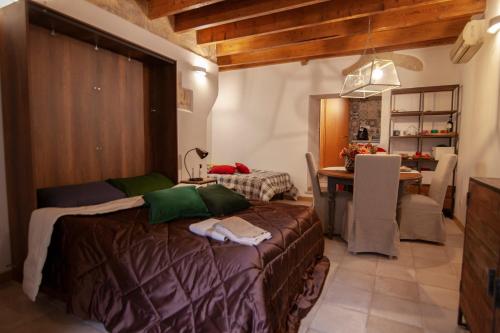 a bedroom with a bed and a table and a kitchen at la casetta in Sassari