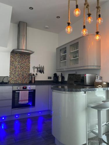 a kitchen with a stove and an island with blue lights at SeaScape in Bexhill