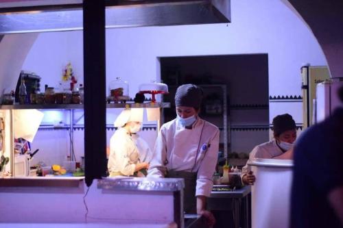 a group of chefs in a kitchen preparing food at Hostal Yakumama in Cuenca