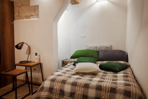 a bedroom with a bed with green pillows on it at la casetta in Sassari