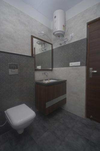 bagno con servizi igienici, lavandino e specchio di Ka10 SQUARE HOTEL & BANQUETS a Jaipur