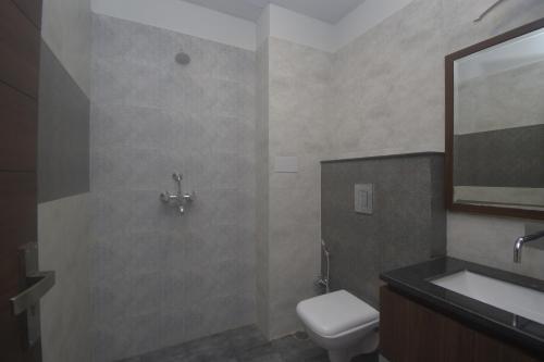 a bathroom with a toilet and a sink and a mirror at Ka10 SQUARE HOTEL & BANQUETS in Jaipur