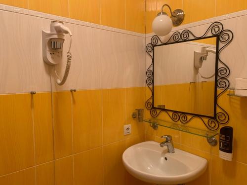a bathroom with a sink and a mirror at Hotel Penzion Trámky in Vikýřovice