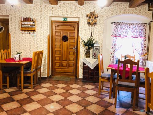 a dining room with a table and chairs and a door at Hotel Penzion Trámky in Vikýřovice