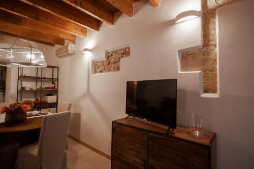 a living room with a flat screen tv on a wooden cabinet at la casetta in Sassari