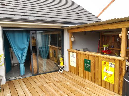 eine Holzterrasse mit Glasschiebetür in der Unterkunft Dépendance Les Ecloses in Chailloué