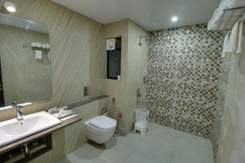 a bathroom with a toilet and a sink at The Divine Resort Somnath in Somnath