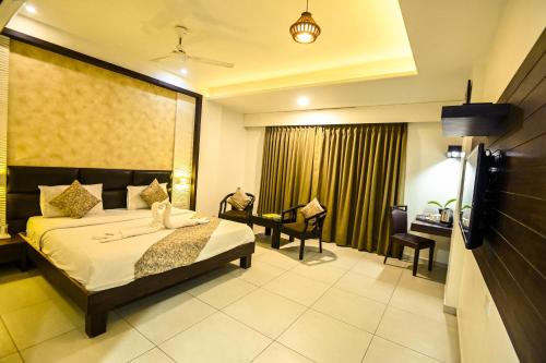 a hotel room with a bed and a desk and chairs at The Divine Resort Somnath in Somnath