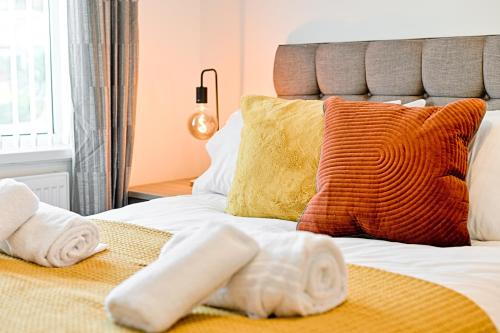 ein Bett mit Handtüchern und Kissen darauf in der Unterkunft 4-Bed - 2 Bath - Off-Road parking - Ideal for Contractors in Swansea