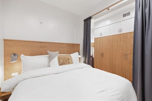 a bedroom with a large white bed with a wooden headboard at The Iris in Charleston