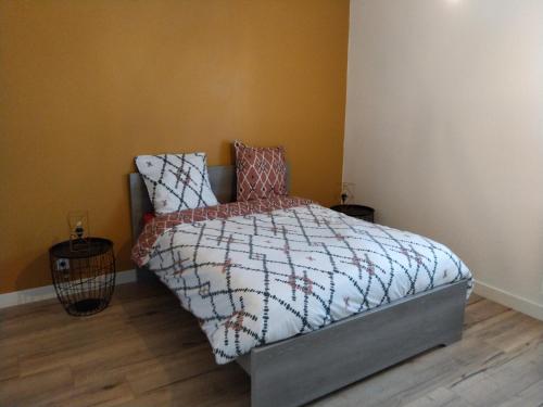 a bedroom with a bed and two pillows on it at Maison Les Ecloses in Chailloué