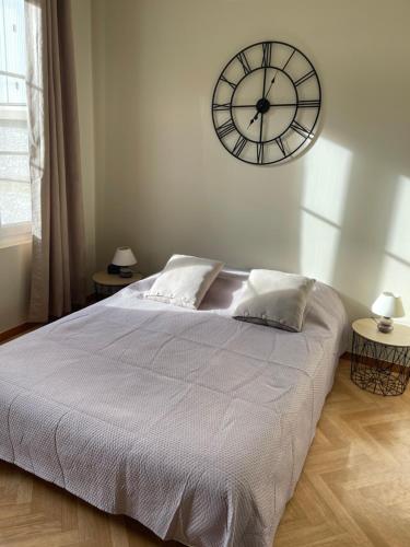 a bedroom with a large bed with a clock on the wall at Le Studio de Louise, Centre-ville de Saint Valery in Saint-Valéry-sur-Somme