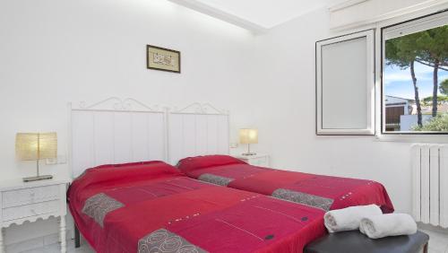 a white bedroom with a large bed with red sheets at 1Albo01 - Llafranc in Calella de Palafrugell