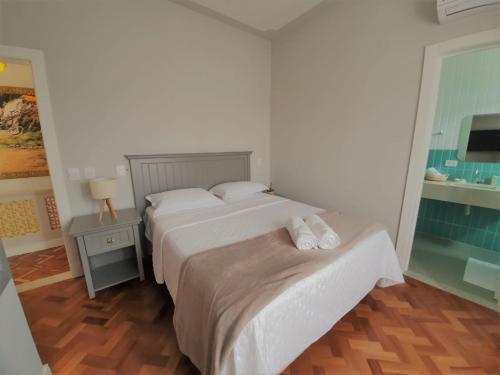 a bedroom with two beds and a table with a lamp at Paranaguá Lodge in Paranaguá