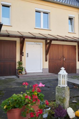 a garage with a white door and some flowers at Gemütliche Ferienwohnung in ländlicher Lage in Riesa
