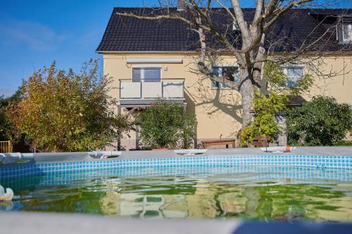 a swimming pool in front of a house at Gemütliche Ferienwohnung in ländlicher Lage in Riesa