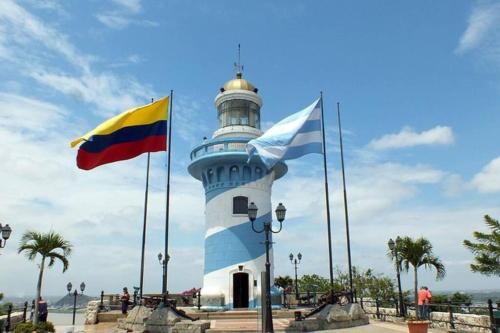 a lighthouse with two flags in front of it at Ecusuites Puerto Santa Ana - River Junto a Hotel Wyndham in Guayaquil