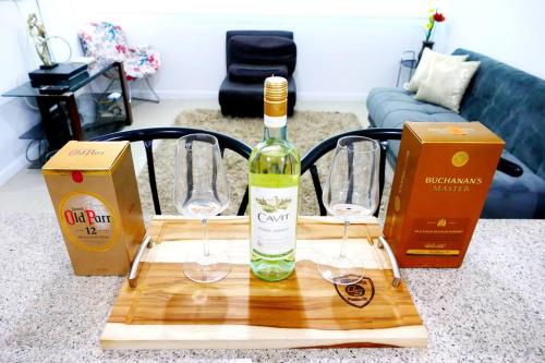 a bottle of wine and two wine glasses on a table at Ecusuites Puerto Santa Ana - River Junto a Hotel Wyndham in Guayaquil