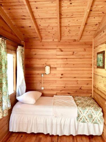 1 dormitorio con 1 cama en una cabaña de madera en LAGİNA BOUTİQUE HOTEL, en Kemer