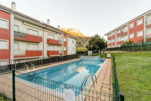 a swimming pool in front of some buildings at apartamento 2 hab - montaña y playa in Gibaja