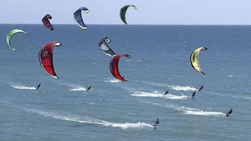 a group of people flying kites in the ocean at Hotel Pegasos in Nikiana