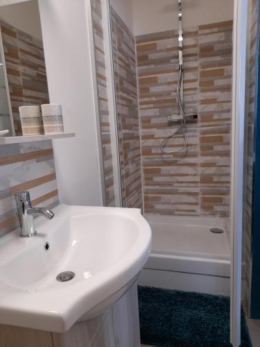 a bathroom with a white sink and a shower at La Pépite de l'océan in Saint-Nazaire