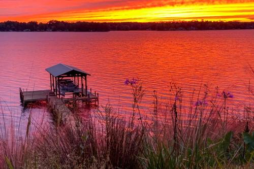 a dock in the middle of a lake at sunset at Elegant Lakefront Gem with Dock and Sunset Views! in Cross Hill