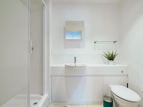 a white bathroom with a sink and a toilet at Jyde Apartments - Sheffield City Centre in Sheffield