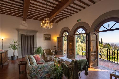a living room with a couch and a chandelier at Villa Colle Olivi in Pescia