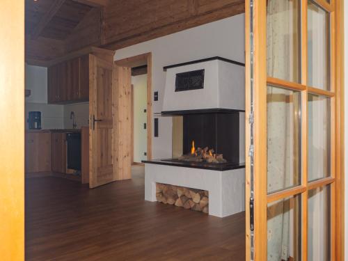 a living room with a fireplace in the middle of it at Der Anderlbauer am See in Schliersee