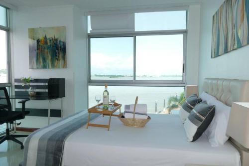a bedroom with a bed and a view of the ocean at Ecusuites Resort Riverfront Family Dept Santa Ana Gye in Guayaquil