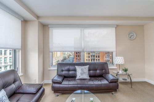 a living room with a leather couch and a glass table at Furnished 2 Bedroom Apartment near National Museum apts in Washington, D.C.