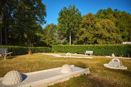 un parc avec trois grandes sculptures blanches dans l'herbe dans l'établissement Tiki House M-Home-Climatisé - Belle parcelle !, à Saint-Chéron
