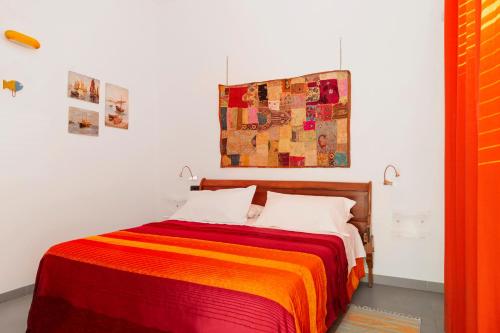 a bedroom with a bed with a colorful blanket at B&B Monterosso in Realmonte