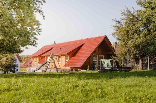 a house with a red roof in a field at Holzerhof-Ferienwohnungen in Gengenbach