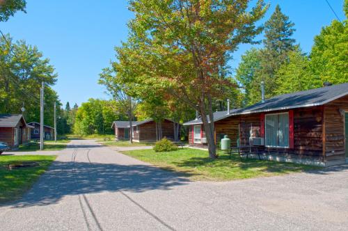 a row of cabins on a road next to a tree at Glenview Cottages in Sault Ste. Marie