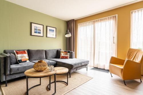 sala de estar con sofá y mesa en Appartement De Bosrand, Resort Amelander Kaap, en Hollum