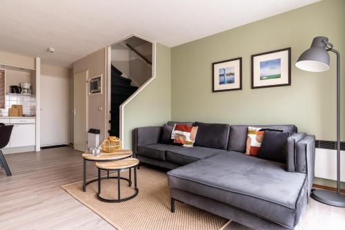 ein Wohnzimmer mit Sofa und Tisch in der Unterkunft Appartement De Bosrand, Resort Amelander Kaap in Hollum