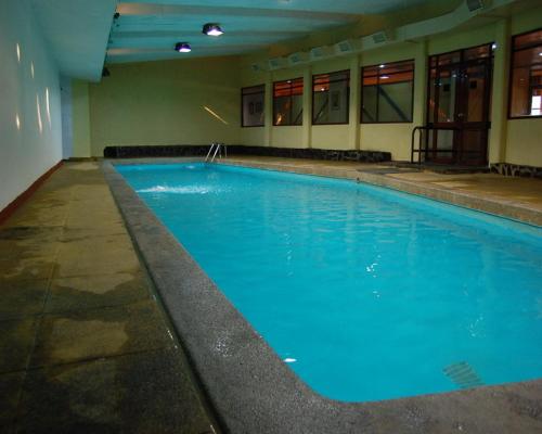a large blue swimming pool in a building at Apartamento El Colorado in El Colorado